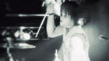 a black and white photo of a man singing into a microphone in a dark room