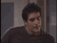a man in a black shirt is making a funny face and says `` alright '' .