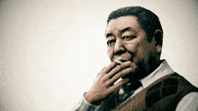 a man smoking a cigarette with his hand on his mouth