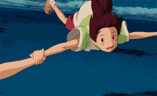 a person is holding a child 's hand while she is flying through the air