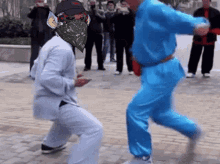 a man in a suit and a man in a blue suit are dancing