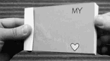 a person is holding a card that says my with a heart drawn on it