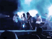 a group of people are dancing on a stage with the words rbd.gif above them