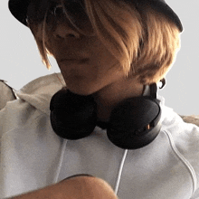a woman wearing headphones and a hat is looking at the camera .