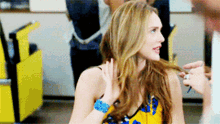 a woman in a yellow and blue dress is talking to a man