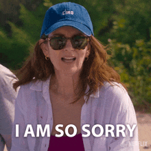 a woman wearing sunglasses and a blue hat is saying i am so sorry