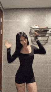 a woman in a black dress is dancing in a bathroom .
