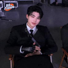 a man in a suit and tie sitting in a chair with the word pisode on the bottom