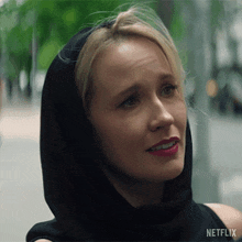 a close up of a woman wearing a black hoodie with netflix on the bottom