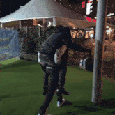 a man is carrying another man on his back in front of a mcdonalds sign
