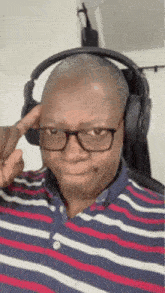 a man wearing headphones and glasses is making a face .
