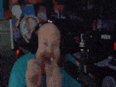 a man wearing headphones and a rode microphone is making a funny face