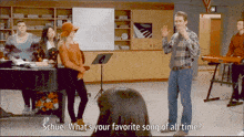 a man stands in front of a group of people and says " what 's your favorite song of all time ? "