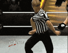 a referee in a wrestling ring with a w live logo