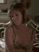 a woman in a leopard print bra is laying on a bed