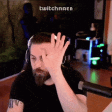 a man wearing headphones is giving a high five in front of a screen that says twitcharen