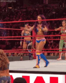 a woman in a bikini is dancing in a wrestling ring ..