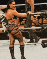 a woman in a wrestling ring with a tattoo on her back that says ' swag ' on it