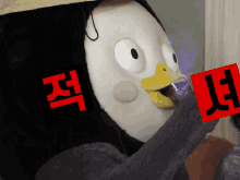 a stuffed penguin holding a red sign with the letters jl on it