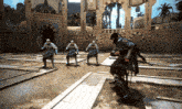 a group of men are playing a video game and one of them is kneeling down