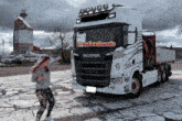 a woman is standing in front of a truck that says scania
