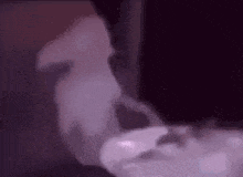 a person is smoking a hookah in a dark room with smoke coming out of it .