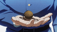 a man in a blue shirt is holding a small ball in his hand