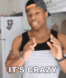 a man wearing a hat says it 's crazy in a kitchen