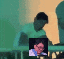 a blurry picture of a man wearing glasses and a blue shirt