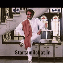 a man in a white shirt and red scarf is dancing in a room with the words starttamilchat.in on the bottom