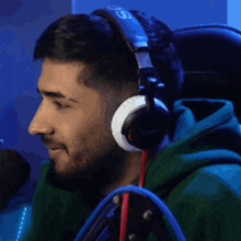 a man wearing a green hoodie and headphones with the number 51 on them