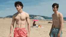 a man without a shirt is talking to another shirtless man