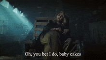 a woman sitting in a dark room with the words oh you bet i do baby cakes above her