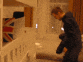 a man standing next to a bunk bed with a british flag pillow