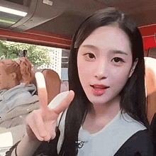a woman giving a peace sign while sitting in a bus