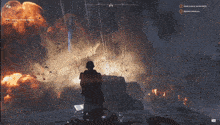 a video game screen shows a man standing in front of a huge explosion