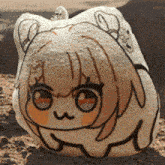 a stuffed animal with a girl 's face on it is laying on the ground .
