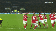 a group of soccer players on a field with fc bayern.tv on the bottom
