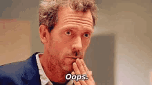 a man in a suit and tie is making a funny face and saying oops .