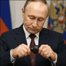a man in a suit and tie is holding something in his hands with the word russia on the bottom right