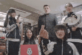 a group of people are posing for a picture and one of them is wearing a jacket that says love on it