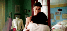 a man and woman are hugging each other in a bedroom .