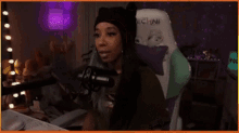 a woman is sitting in a chair in front of a microphone in a room .