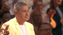 a man in a yellow suit giving a peace sign