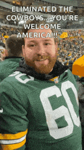 a man wearing a green bay packers jersey with the number 60 on the front