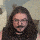 a man with long hair and glasses has a beard