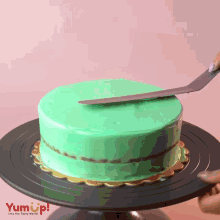 a cake with green frosting is on a black plate that says yumup