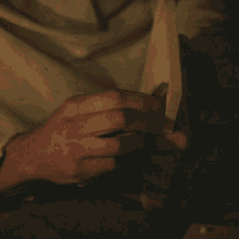 a close up of a person 's hands holding a piece of wood