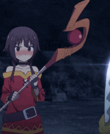 a girl in a red dress is holding a stick with a belt around her waist