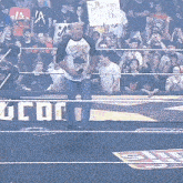 a man in a wrestling ring holding a sign that says ' the titan 's hit soul bro '